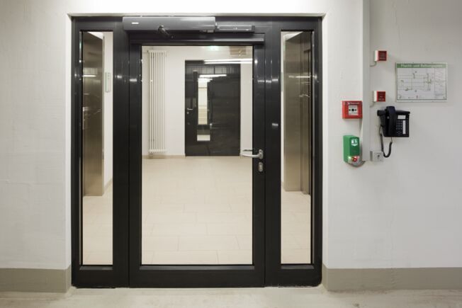 Drehtürantrieb TSA 160 NT F-IS,  GC334 Sensorleiste und die Türzentrale RWS TZ320 SN AP Elektrohydraulisches Drehtürantriebssystem für 2-flügelige Feuer- und Rauchschutztüren mit integrierter Schließfolgeregelung in der Seniorenresidenz Augustinum, Stuttgart.