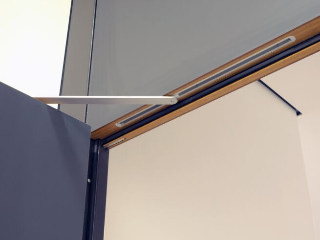 Close-up of GEZE door closer on fire protection door.