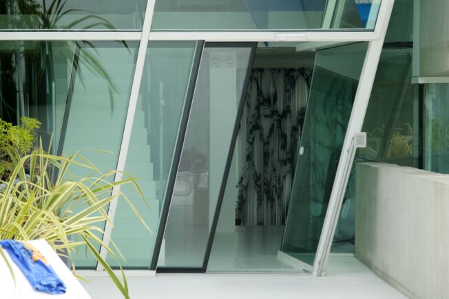 Automatischer Schiebetürantrieb Slimdrive SL geneigt in der Villa Soravia, Millstatt Österreich Automatisches Linear-Schiebetürsystem für den Einsatz an geneigten Glasfassaden
