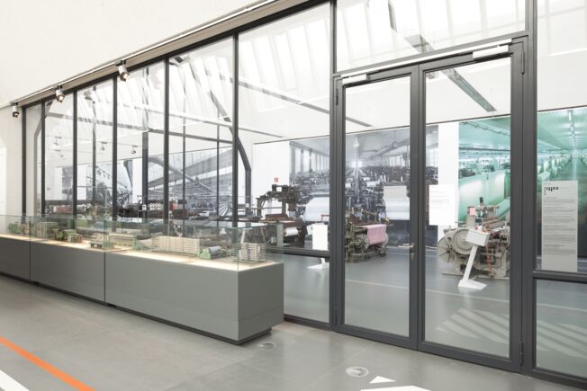 Gleitschienentürschließersystem TS 5000 ISM, verbaut im Textil- und Industriemuseum in Augsburg. Türschließer für zweiflügelige Türen mit Schließfolgeregelung und mit integrierter Öffnungsdämpfung, was bewirkt, dass die stark aufgeworfene Türen abgebremst wird.