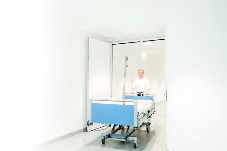 Hospital bed passing through an accessible fire protection door