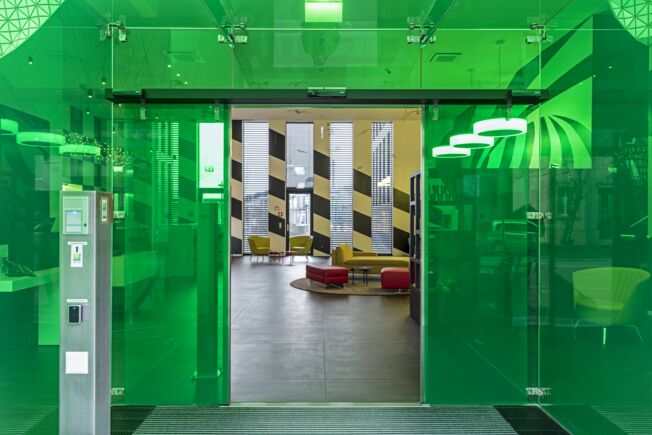 Automatisme de portes coulissantes Slimdrive SL NT-FR, installé dans la Grosspeter Tower de Bâle Système de porte coulissante linéaire automatique pour issues de secours avec une faible hauteur totale et une ligne de conception claire