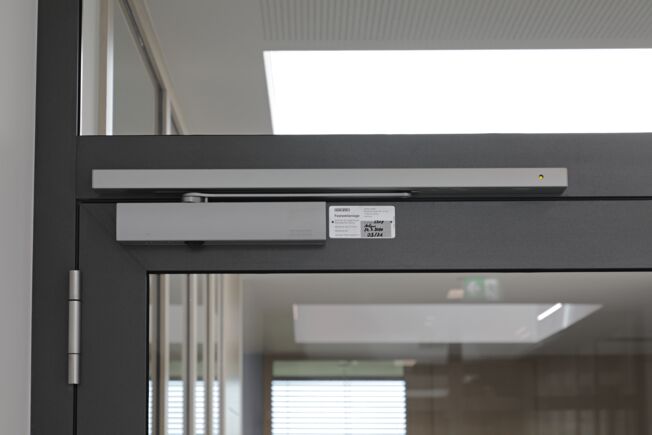 GEZE TS 5000 R overhead door closer with integrated smoke switch control unit, which sends a signal to automatically close the door in case of 