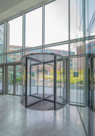 Deloitte Headquarter   Detailansicht der Revo.PRIME von innen Innenansicht der Karusselltür, die Offenheit, fließende Übergänge und ein einladend-elegantes Ambiente vermittelt.
