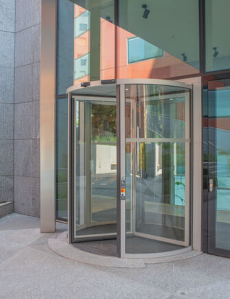 Deloitte Headquarter   Außenansicht einer einzelnen Revo.PRIME Karusselltür Außenansicht der Karusselltür, die das hochwertige Design und die fließende Bewegung hervorhebt und architektonische Eleganz und Präzision vermittelt.