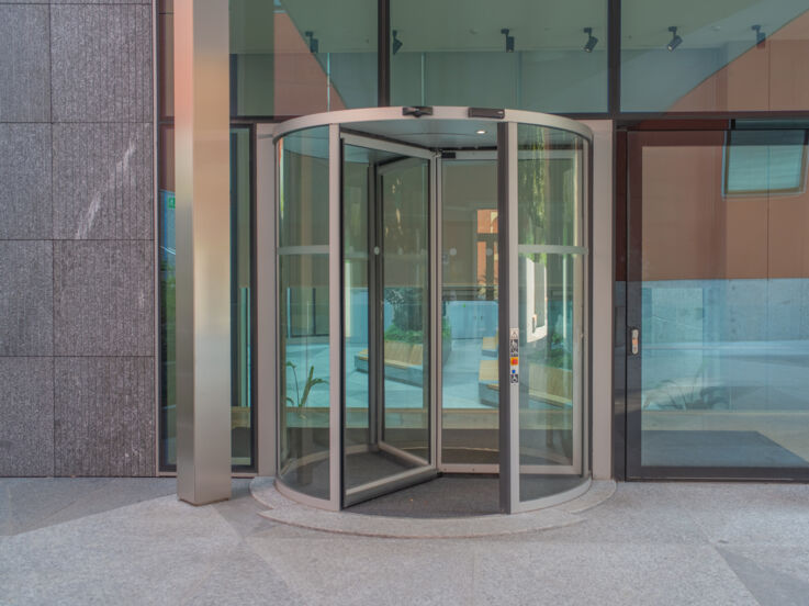 Ingresso dell’edificio con porta girevole Revo.PRIME in primo piano 