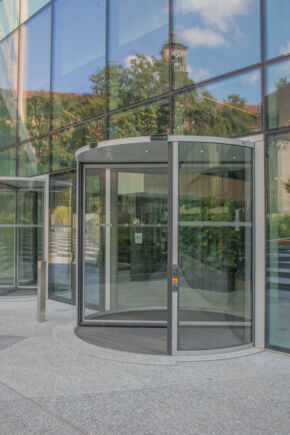 Deloitte Headquarter   Außenansicht der Lobby mit zwei Revo.PRIME Karusselltüren Außenansicht der Lobby mit zwei Revo.PRIME Karusselltüren. Im Vordergrund ist die erste Automatiktür zu sehen, die den modernen, einladenden und eleganten Charakter des Eingangs unterstreicht.