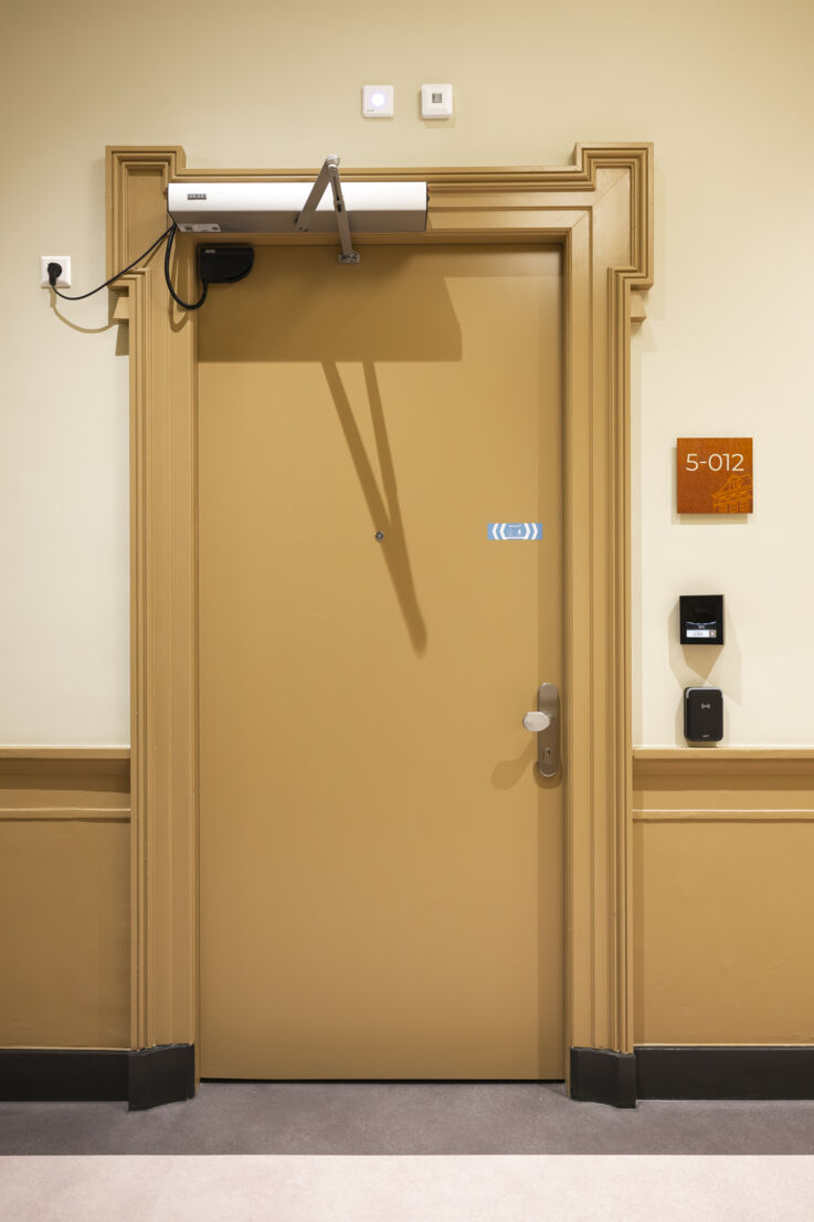 View of a closed room door fitted with a GEZE door closer