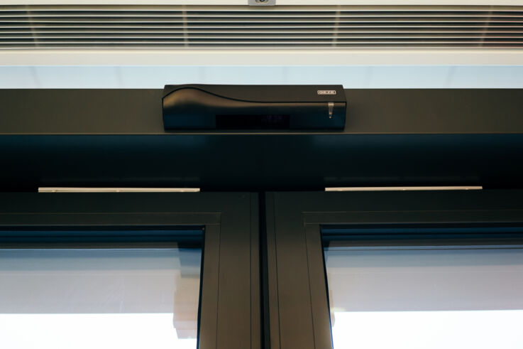 Visning av en Kombimelder på en skyvedør i en dm-butikk.